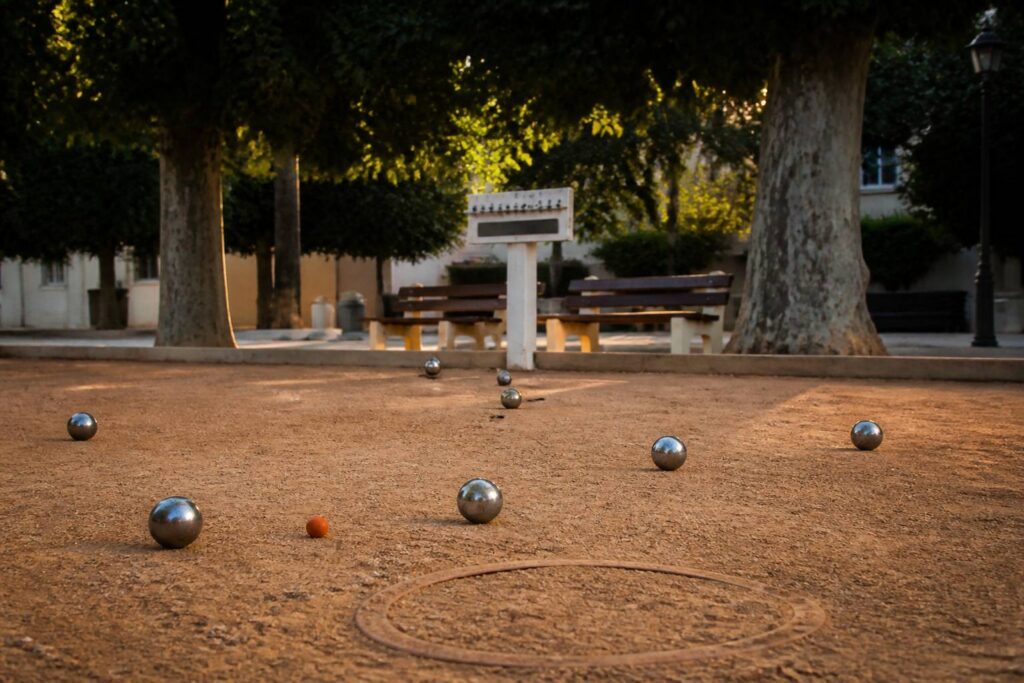 Boulodrome en fin d'après-midi avec cercle, cochonnet et boules de pétanque sur terre battue