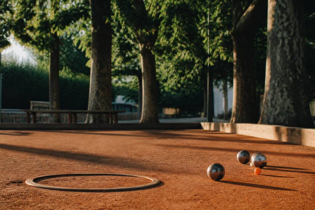 Terrain de pétanque avec boules métalliques près du cochonnet