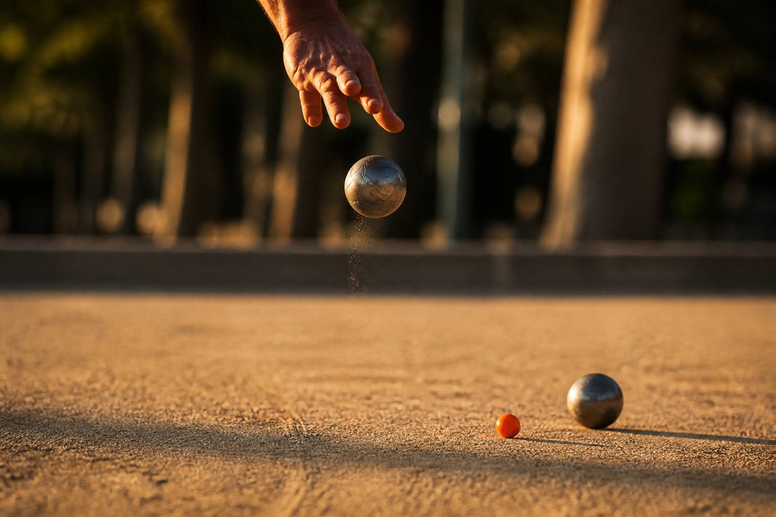 Main lançant une boule de pétanque au-dessus du terrain